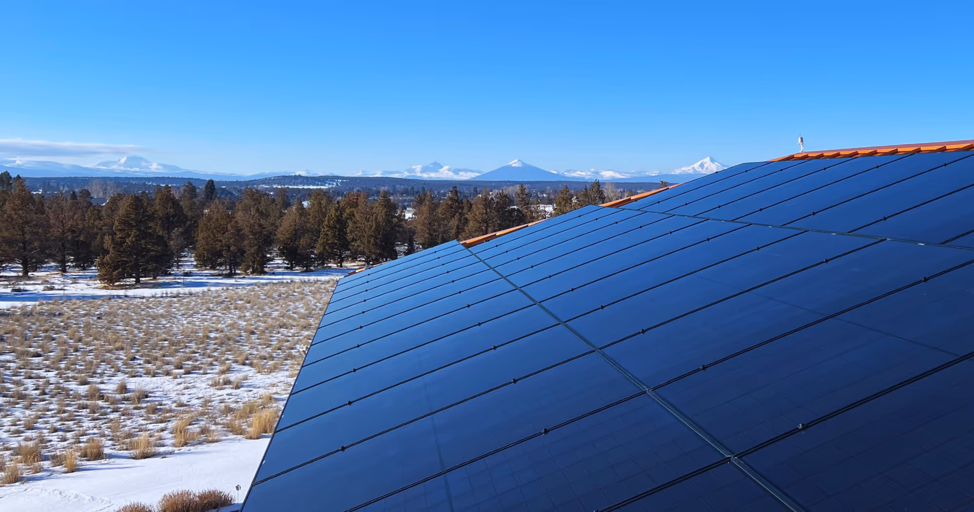 Solar panels on an Oregon home overlooking the snow-capped Cascade mountains near Bend