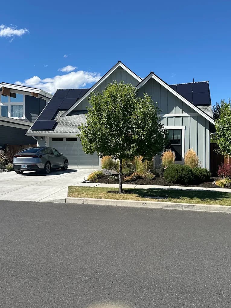 Finished residential solar install with an EV charging in the driveway of an Oregon home